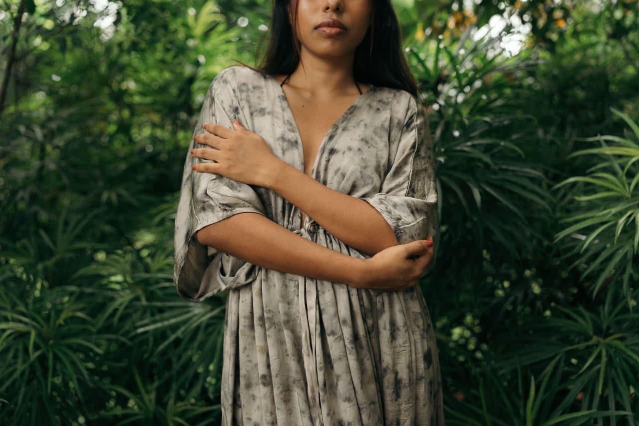 Woman wearing a naturally dyed Niraé garment among botanicals
